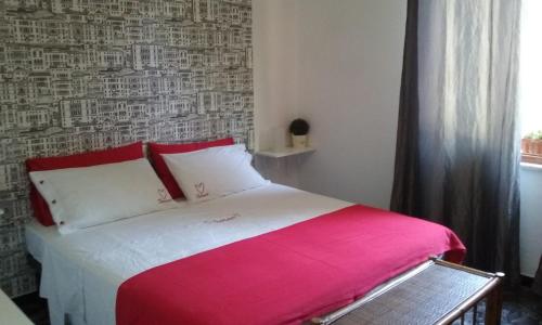 Schlafzimmer mit einem Bett mit einer roten und weißen Decke in der Unterkunft Casa Tra Il Verde E Il Blu in Genua