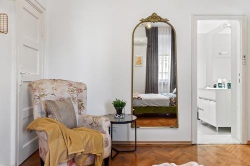 - un salon avec une chaise et un miroir dans l'établissement Bucharest Ultracentral Apartment, à Bucarest