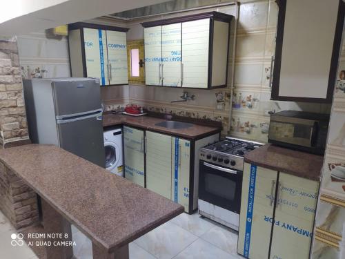 uma cozinha com um frigorífico e um fogão forno superior em City Square شقق فندقية مكيفة باطلالة علي البحر em Alexandria