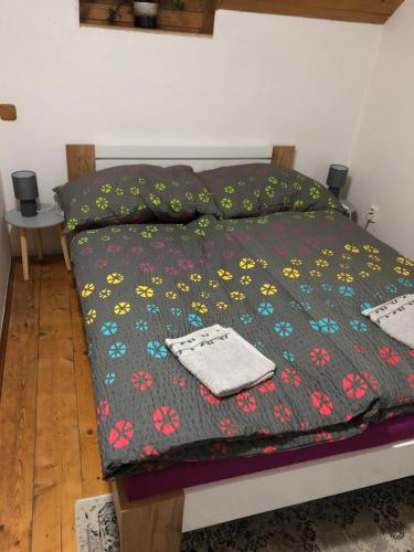 uma cama com um cobertor com flores em Chalupa Kociánka em Loučná nad Desnou