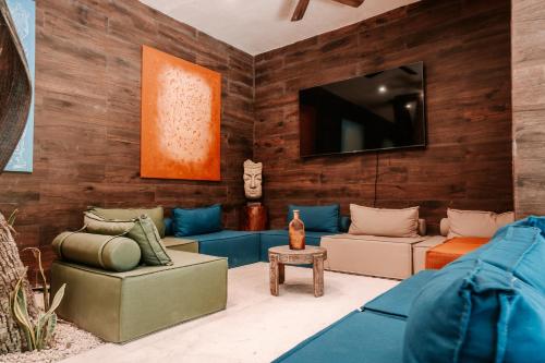 a living room with furniture and a flat screen tv at Kaaba Luum Jungle Villas in Chemuyil
