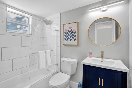 een badkamer met een toilet, een wastafel en een spiegel bij Rustic Retreats Cozy 1BR For 4 Guests Minutes From Las Olas in Fort Lauderdale
