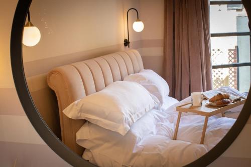 a mirror reflecting a bed with white pillows and a table at TOFY (The Old Forge York) in York