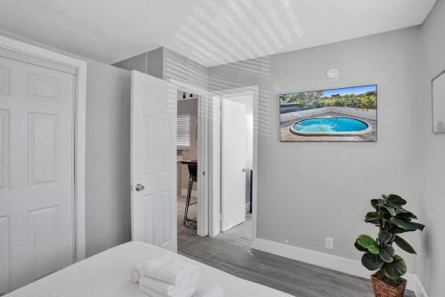 een witte kamer met een bed en een schilderij aan de muur bij Rustic Retreats Beachy 1BR for 4 guests in the heart of Fort Lauderdale in Fort Lauderdale