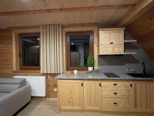 a kitchen with wooden cabinets and a counter top at Stella Haus in Dzianisz