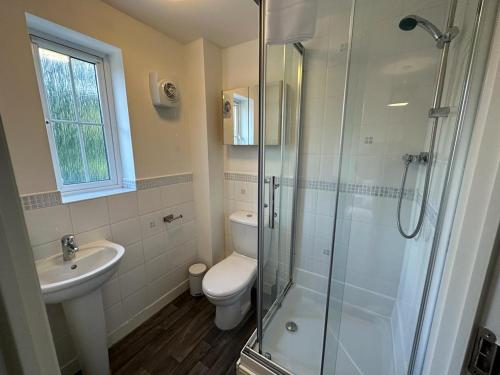 een badkamer met een douche, een toilet en een wastafel bij Chervil House by YourStays in Newcastle under Lyme