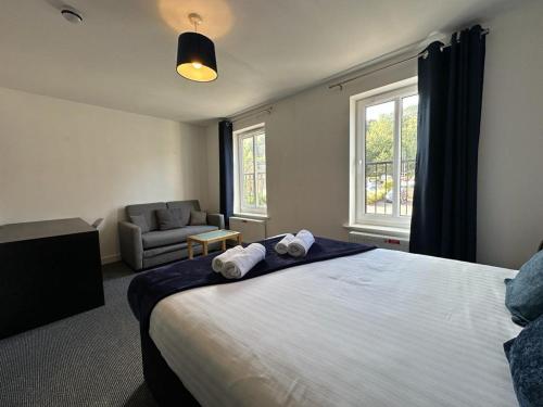 a bedroom with a bed and a chair and a window at Chervil House by YourStays in Newcastle under Lyme