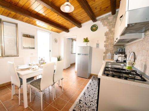 a kitchen with a table and a white refrigerator at Casa vacanze San Matteo in Scicli