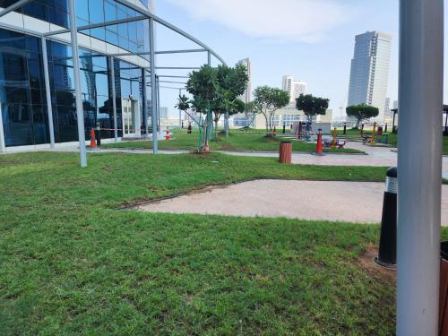 a building with a park in front of a building at HARF4606 Huge water front 1BR Apt with 2 Sofa Beds in Alreem Island in Abu Dhabi