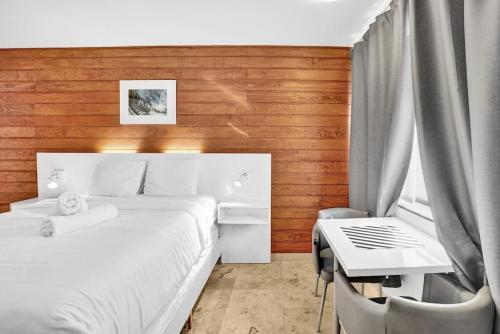 1 dormitorio con cama, escritorio y mesa en Waves Beach Town Studio Apartment en Pompano Beach