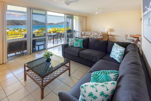 a living room with a couch and a table at Poinciana 109 & Buggy Hamilton Island in Hamilton Island