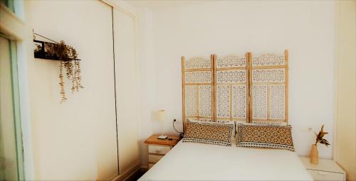 1 dormitorio con cama blanca y pared blanca en Apartamento Las Canastas Cádiz Centro, en Cádiz