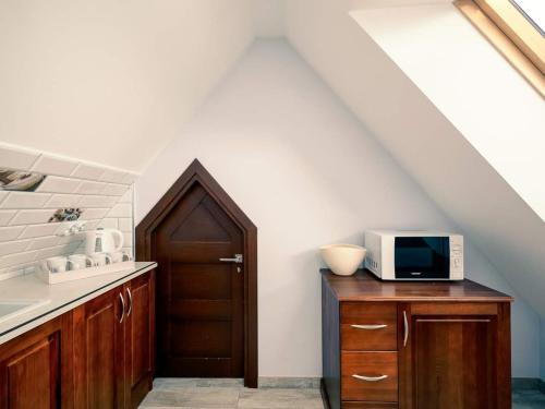 cocina con puerta y microondas en un armario de madera en Willa Pod Górską Lawendą, en Jurgów