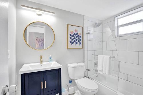 a bathroom with a toilet and a sink and a mirror at Rustic Retreats Beachy 1BR for 4 guests in the heart of Fort Lauderdale in Fort Lauderdale