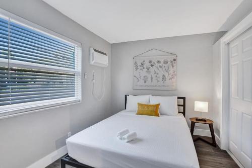 a bedroom with a white bed and a window at Rustic Retreats Beachy 1BR for 4 guests in the heart of Fort Lauderdale in Fort Lauderdale