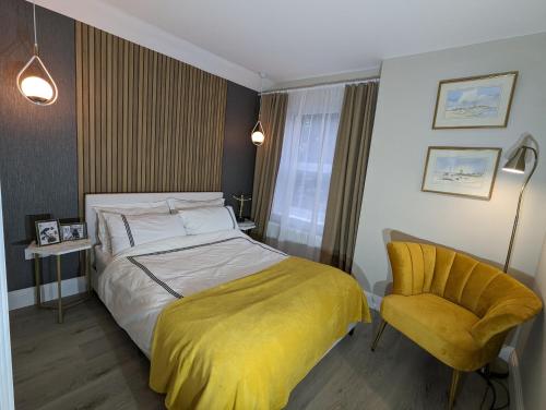 a bedroom with a bed and a yellow chair at GREATER LONDON APARTMENT in London