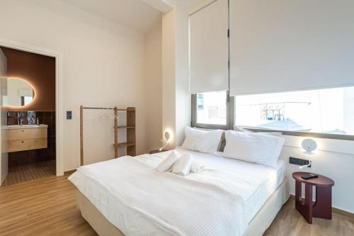 Schlafzimmer mit einem großen weißen Bett und einem großen Fenster in der Unterkunft Central Gem - Kalamata Exclusive Loft16 in Kalamata