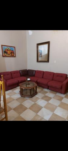 a living room with a red couch and a coffee table at Hermosa casa centrica in La Banda