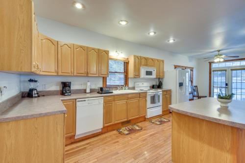 a large kitchen with wooden cabinets and white appliances at Hiawassee Vacation Rental with Grill about 9 Mi to Lake! in Hiawassee