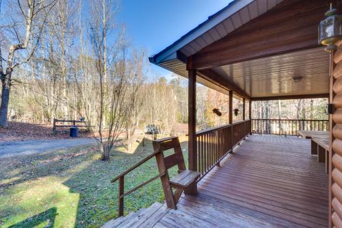 a wooden porch of a cabin with benches on it at Hiawassee Vacation Rental with Grill about 9 Mi to Lake! in Hiawassee