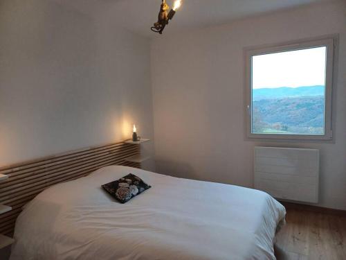 une chambre avec un lit blanc avec une fenêtre dans l'établissement LE CAMPALOU, à Saint-Barthélemy-le-Plain