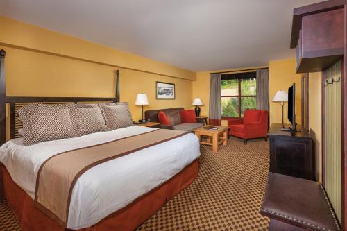 um quarto de hotel com uma cama e uma sala de estar em Bear Creek Mountain Resort em Breinigsville