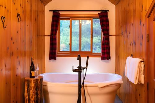 La salle de bains est pourvue d'une baignoire et d'une fenêtre. dans l'établissement Baker Creek By Basecamp, à Lake Louise