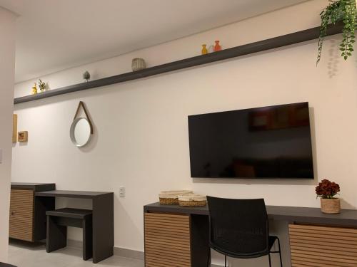 sala de estar con TV de pantalla plana en la pared en FLAT ECO RESORT PRAIA DOS CARNEIROS en Tamandaré