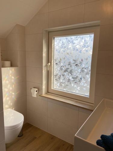 uma casa de banho com uma janela, um WC e uma banheira em BB Sunshine em Schijndel