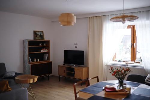 a living room with a table and a television at APARTAMENT Pod Lasem Jedlina Zdrój in Jedlina-Zdrój
