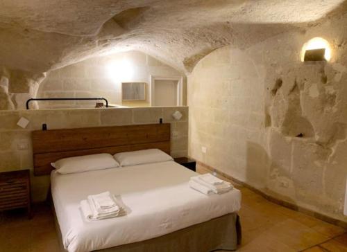 1 dormitorio con 1 cama en una habitación de piedra en Casa Ferri, en Matera