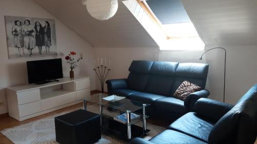 sala de estar con sofá azul y TV en Sterngässle en Deggingen