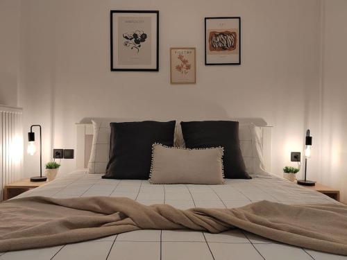 a bedroom with a large bed with three pictures on the wall at Cosy house with garden in Volos