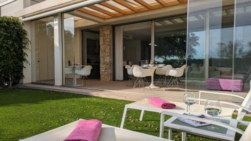 uma casa de vidro com uma mesa e cadeiras num pátio em PARADISE beachfront luxury villa em Villajoyosa