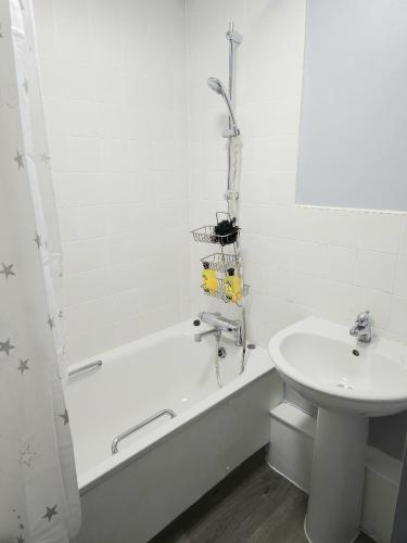 uma casa de banho com um lavatório, uma banheira e um WC. em single room close to the city em Londres