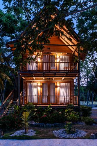 a wooden house with a balcony and lights on it at Hotel Isla del Encanto in Baru