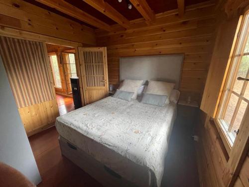 a bedroom with a bed in a wooden cabin at EL BOSQUE ENCANTADO in La Estación