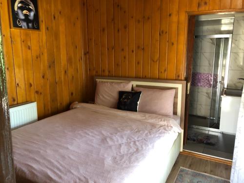 Cama en habitación con paredes revestidas de madera en Sapanca Kanarya Doğa Evleri, en Sakarya