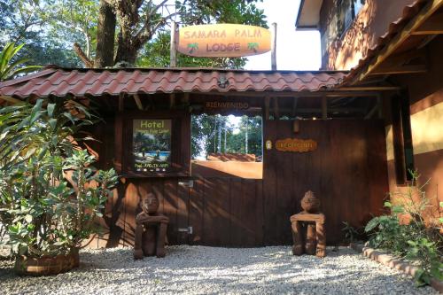 a building with two statues sitting outside of it at Samara Palm Lodge in Sámara