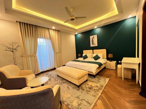 a bedroom with a bed and a couch and a table at COMFORT & LUXURY HOME in Islamabad