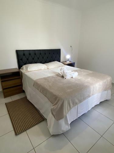 een slaapkamer met een groot bed met een zwart hoofdeinde bij Casa Confortável 02 in Joinville