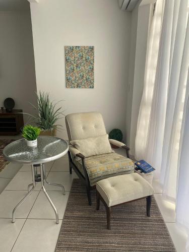 a chair and a table in a living room at RCM Vilas - Casa Confortável 02 in Joinville