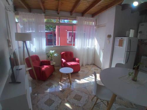 ein Wohnzimmer mit 2 roten Stühlen und einem Tisch in der Unterkunft Departamento Zapata 5ta Mendoza in Mendoza