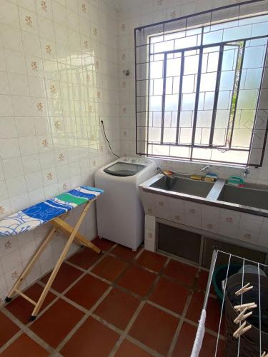 een keuken met een wasmachine en een wastafel bij Casa Confortável 02 in Joinville