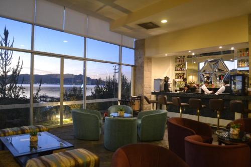 un restaurante con vistas al agua y un bar en Hotel Jose Antonio Puno, en Puno