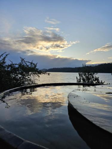 a swimming pool on the shore of a body of water at Cabañas Borgolafquen in Panguipulli