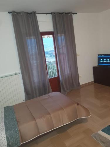 Bett in einem Zimmer mit einem großen Fenster in der Unterkunft B&B Paradiso in Paganica