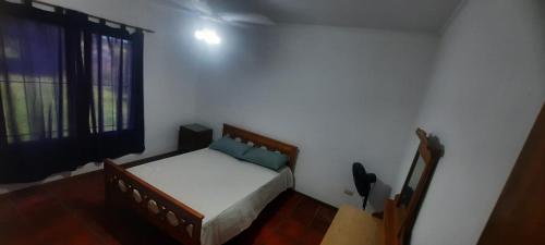 a small bedroom with a bed and a window at El Remanso del Casero in Gualeguay
