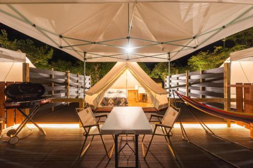 a tent with a table and chairs in front of it at SPRINGS VILLAGE Ashigara-Tanzawa Hot Spring Resort & Glamping - Vacation STAY 42311v in Oyama
