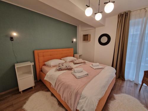 ein Schlafzimmer mit einem großen Bett und einer grünen Wand in der Unterkunft Golden Airport Residence in Otopeni